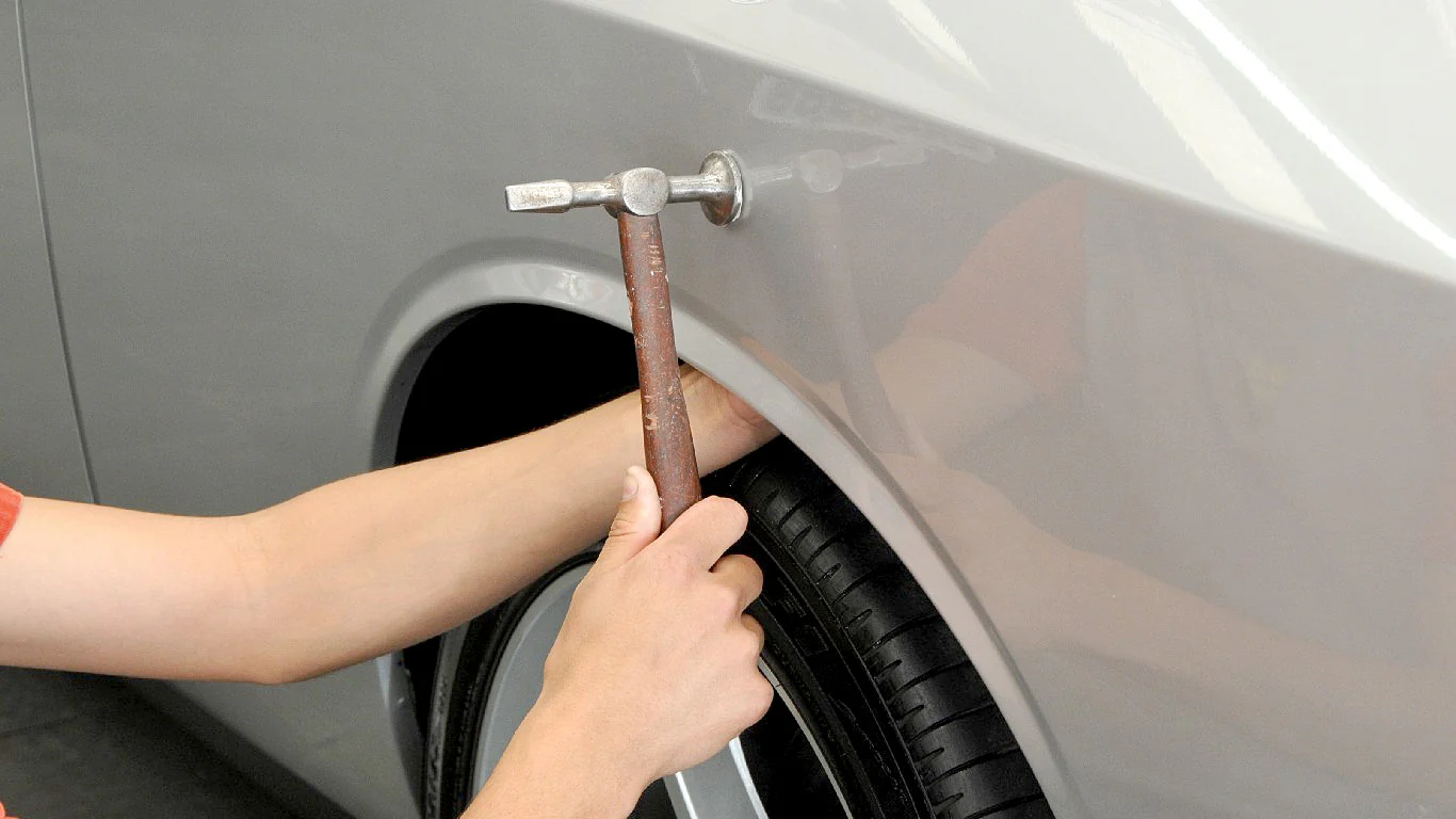 Person polishing a car with a machine