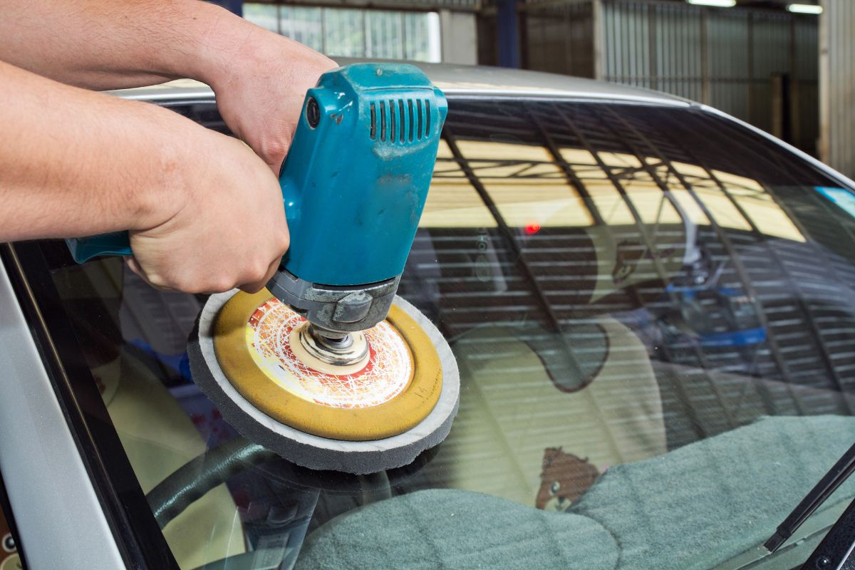 Person polishing a car with a machine