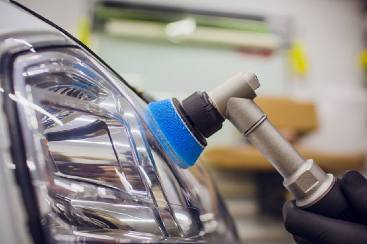 Close-up of a car headlight being polished